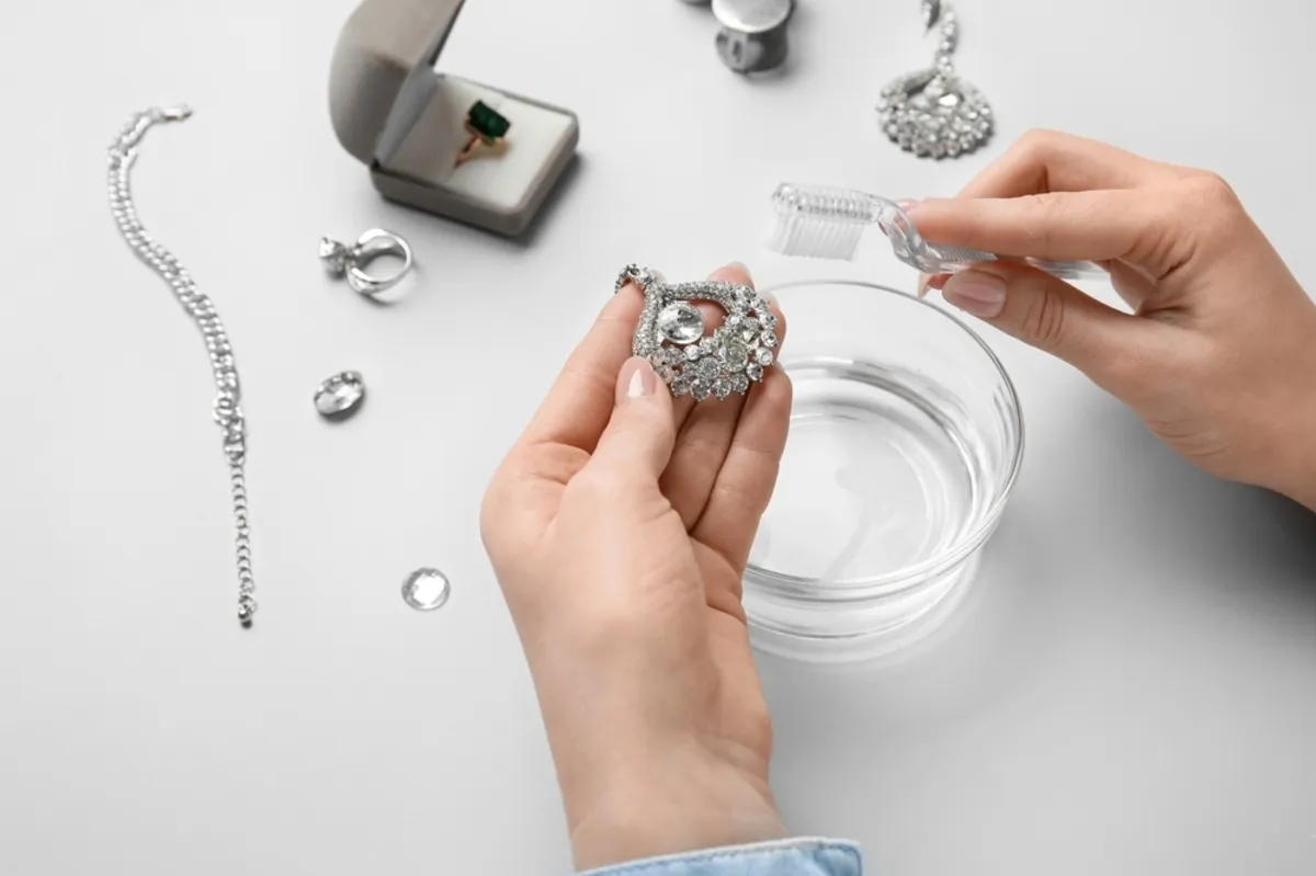 A girl cleans a piece of jewelry | Skylum Blog