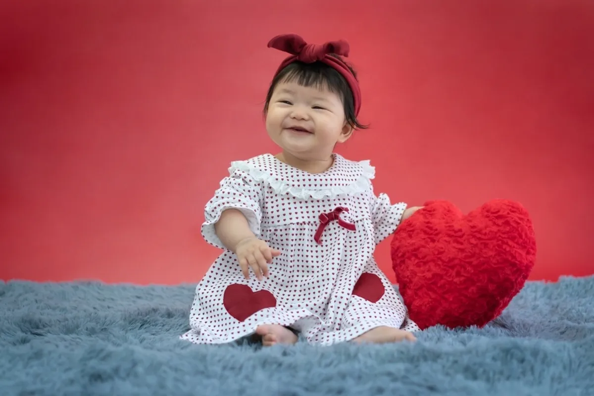 Baby in a dress and a heart pillow | Skylum Blog