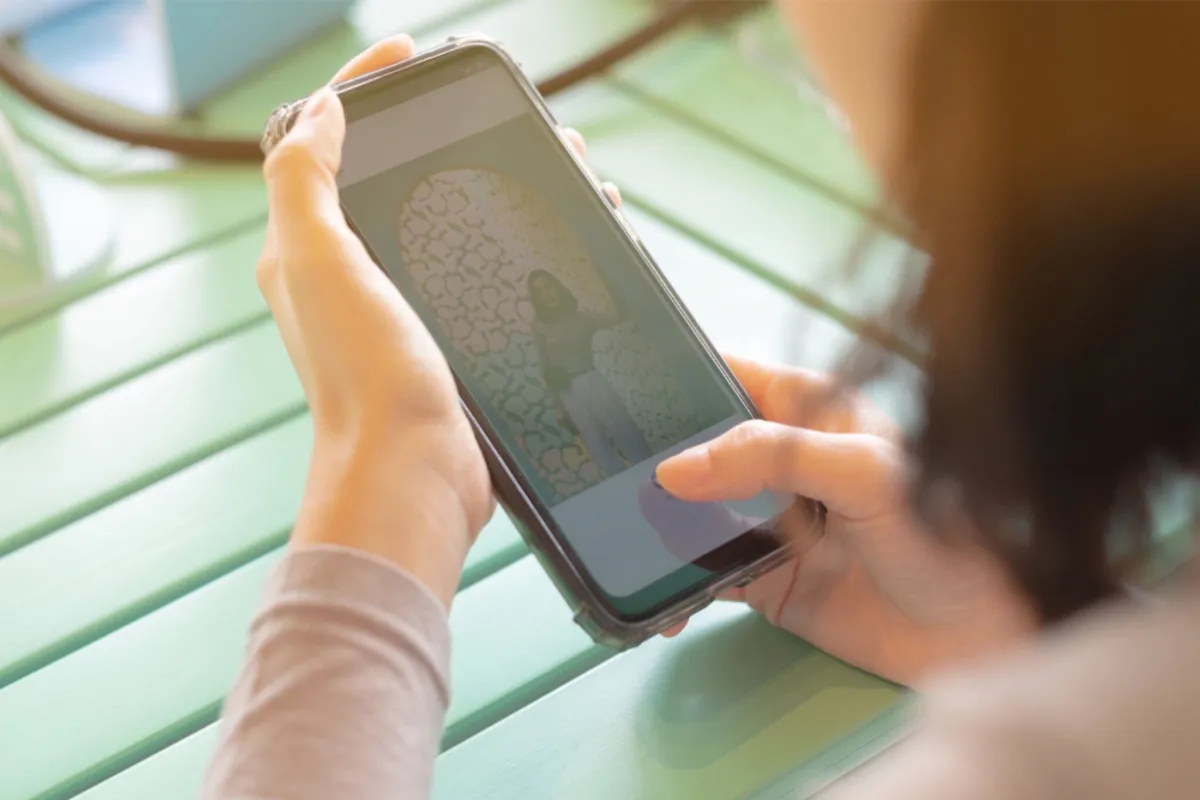 A girl looks through photos on an iPhone | Skylum Blog