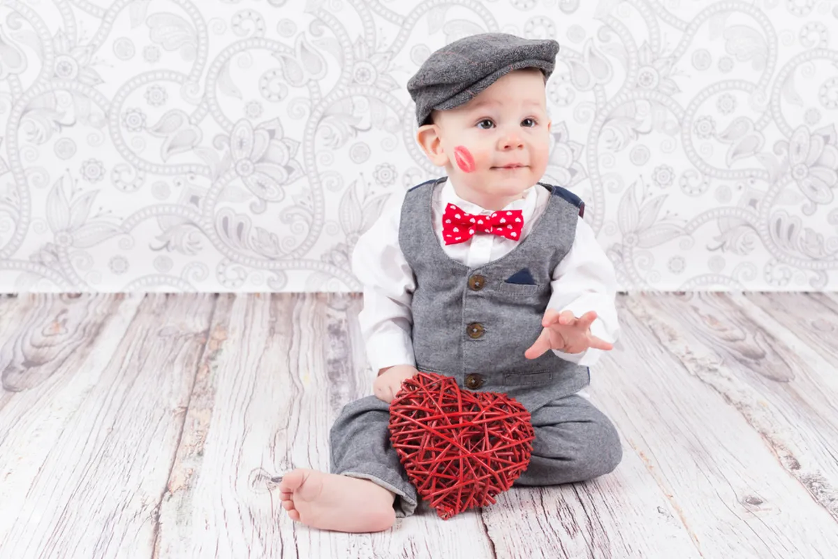 A baby in a suit and holding a heart in his hands | Skylum Blog