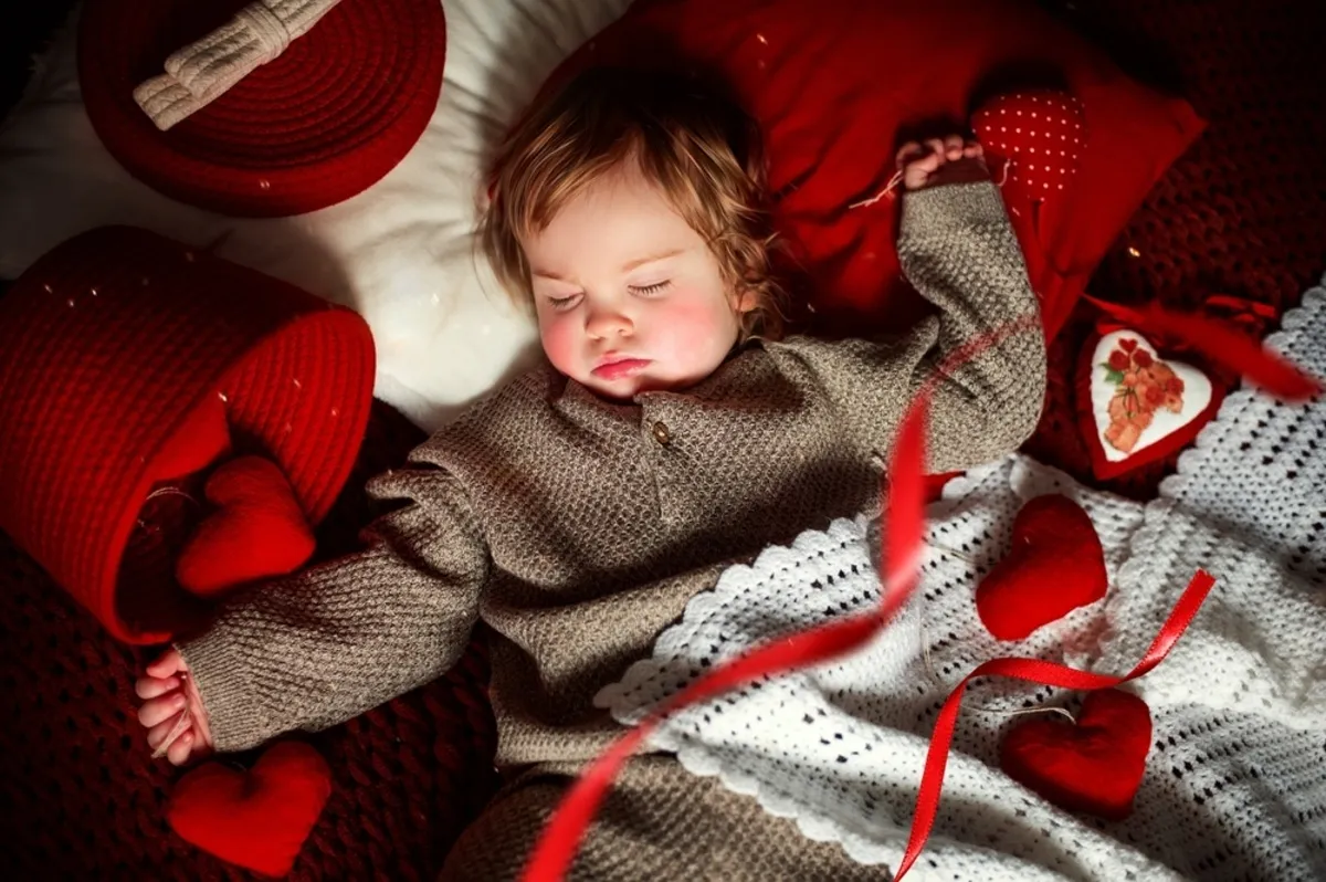 The baby sleeps in a knitted suit covered with a blanket | Skylum Blog