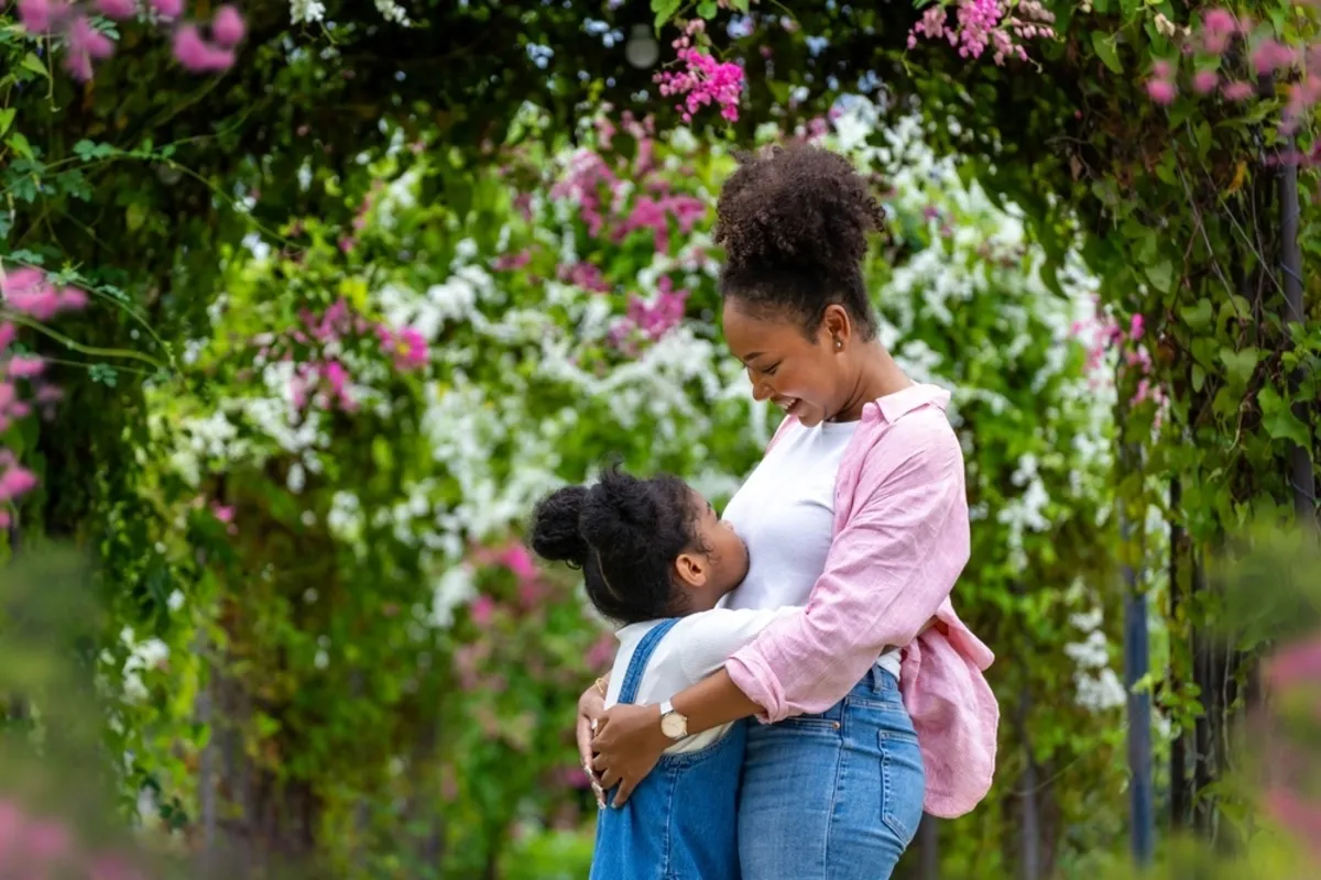 A mother and daughter hug in a park in spring | Skylum Blog