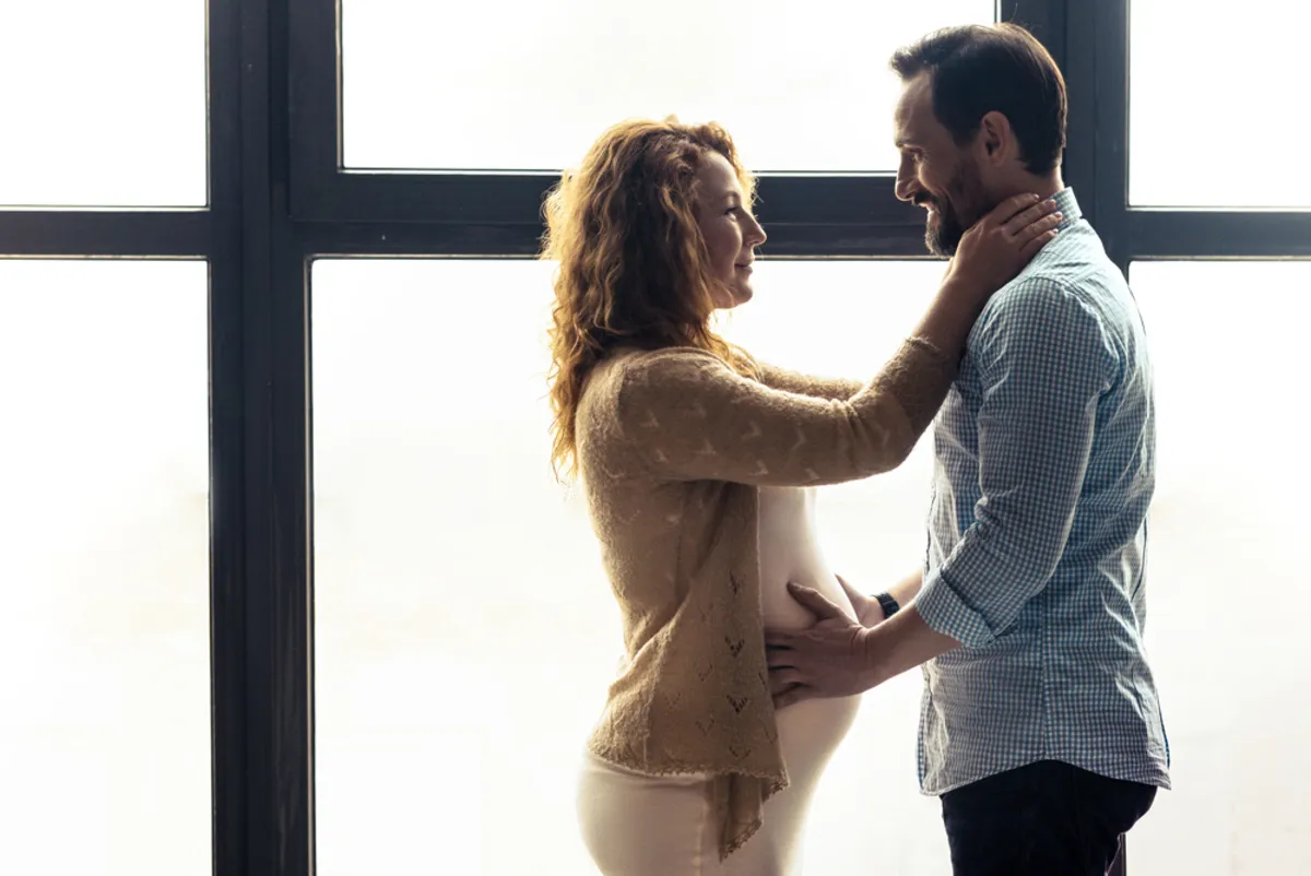 A man and his pregnant woman look into each other's eyes | Skylum Blog