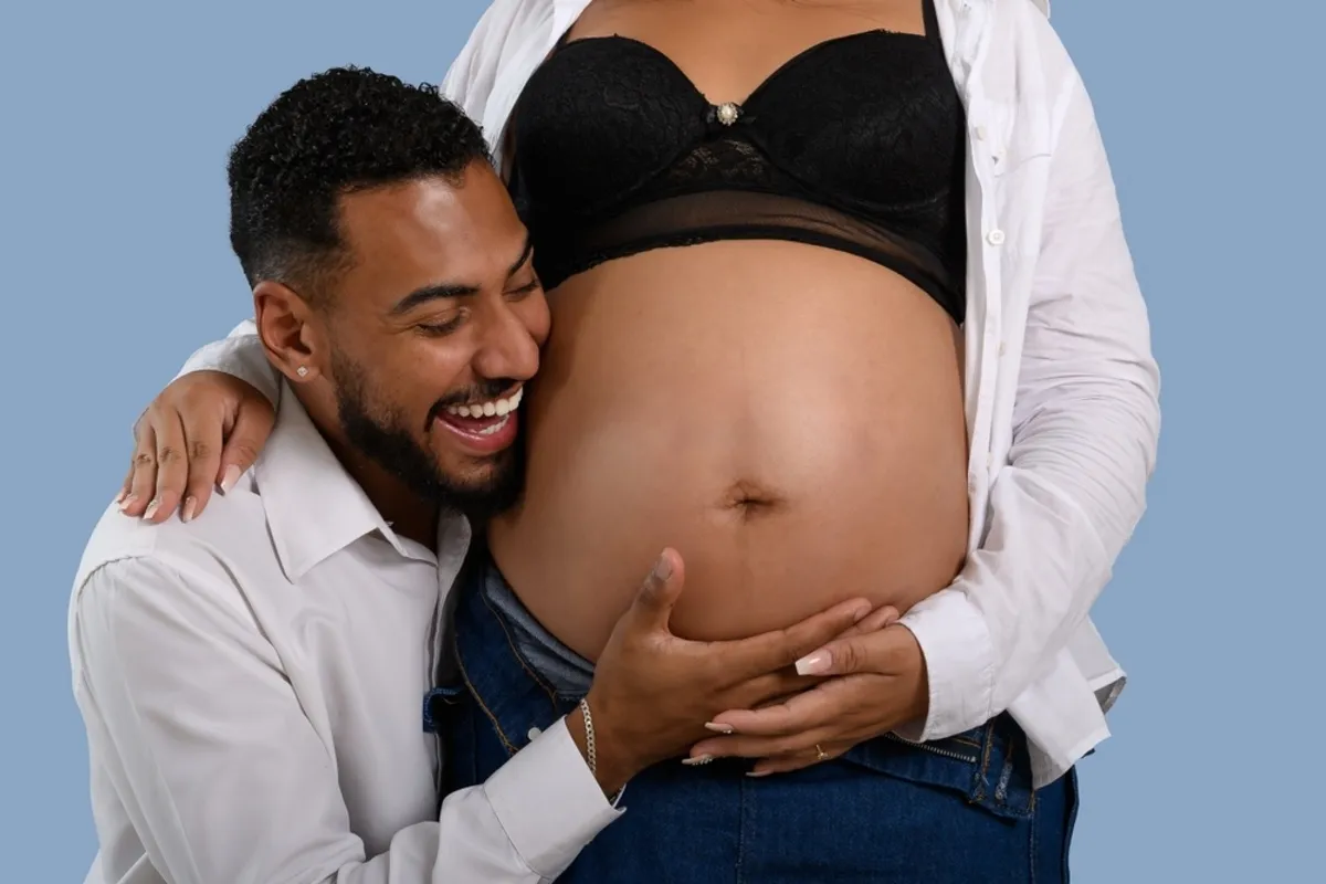 A man holds his pregnant wife's belly | Skylum Blog