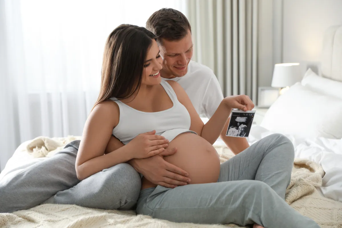 A man and his pregnant wife look at an ultrasound scan | Skylum Blog
