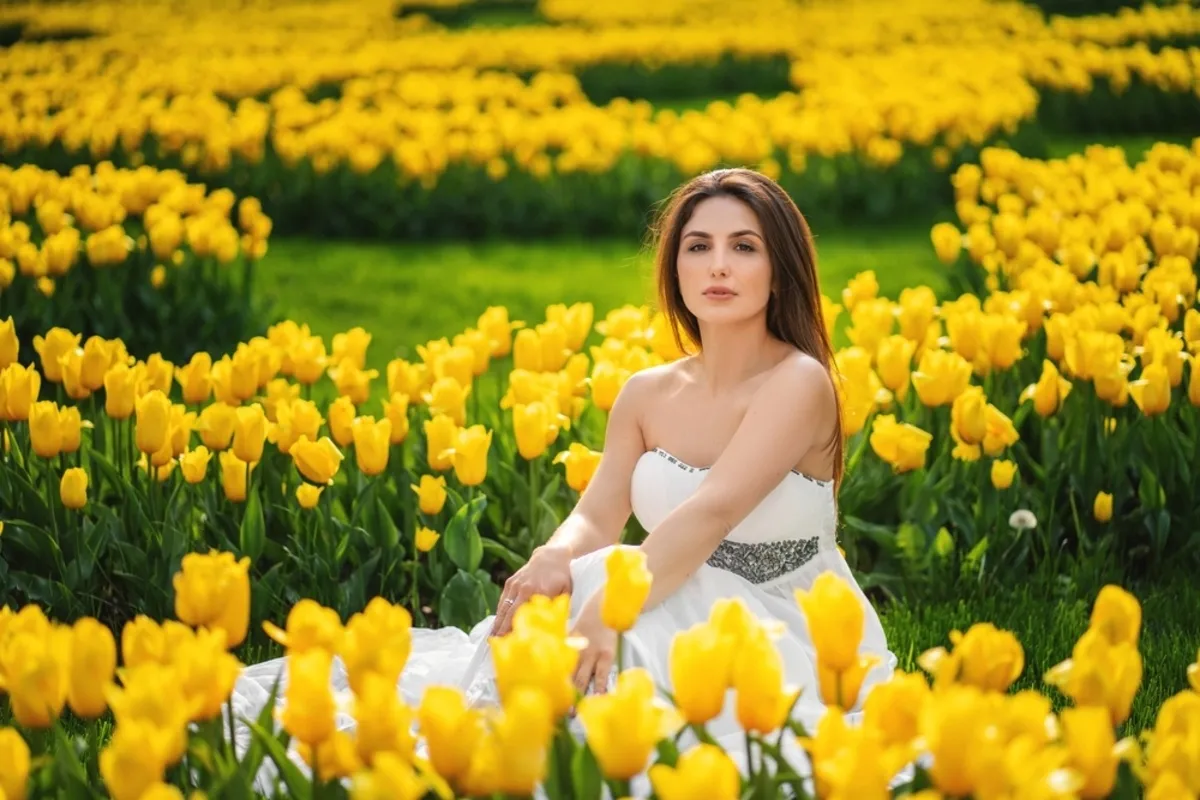 A girl in a white dress in a field of yellow tulips | Skylum Blog
