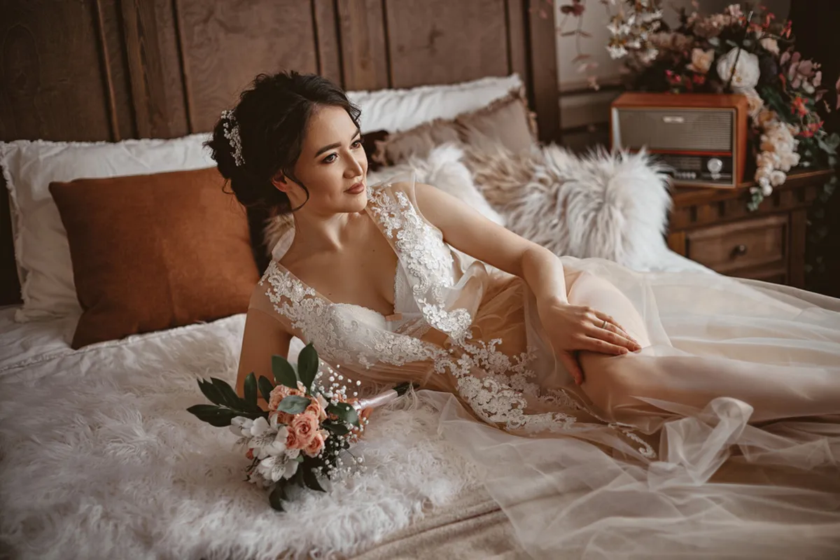 Bride in a transparent lace robe on a bed | Skylum Blog