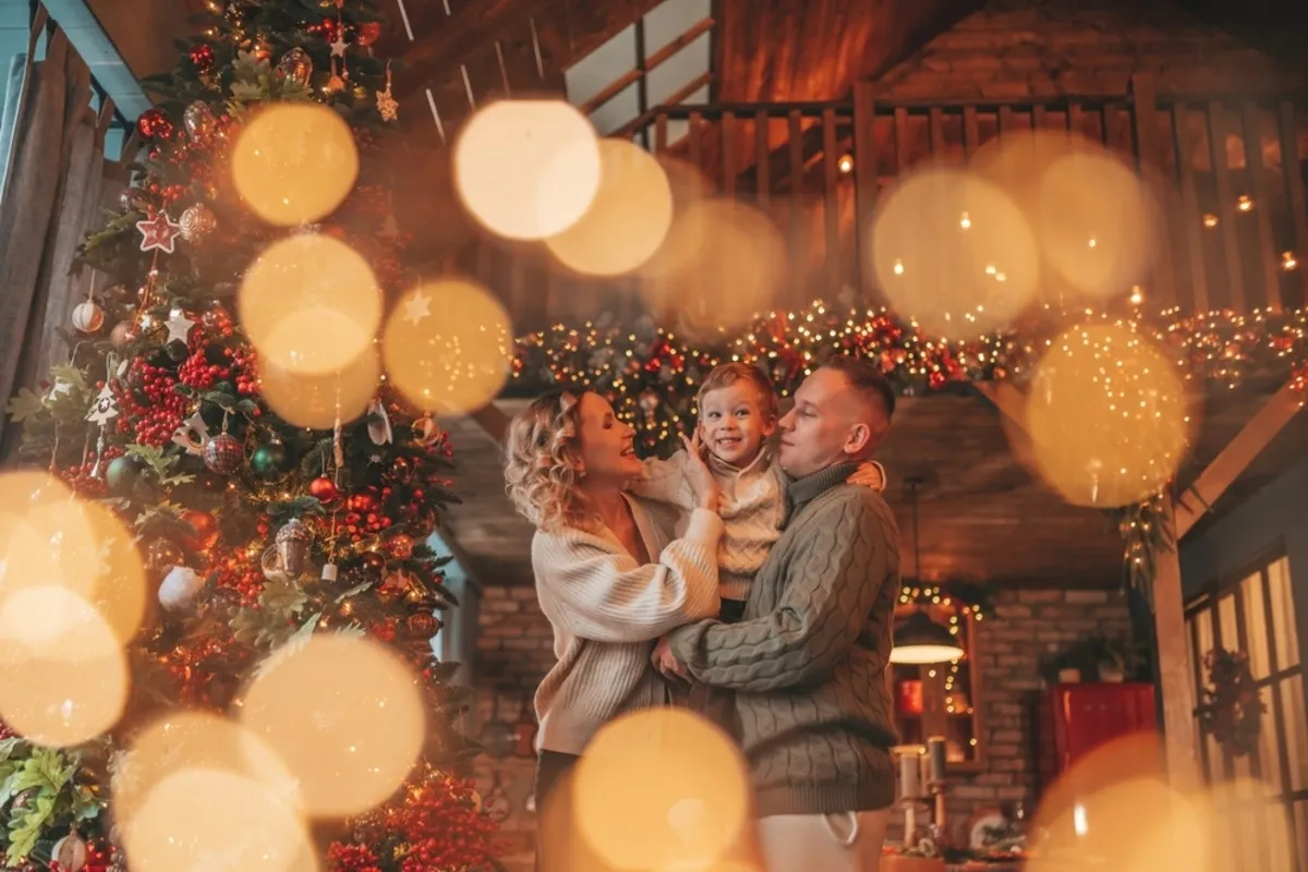 A family photo by the Christmas tree with a bokeh effect | Skylum Blog