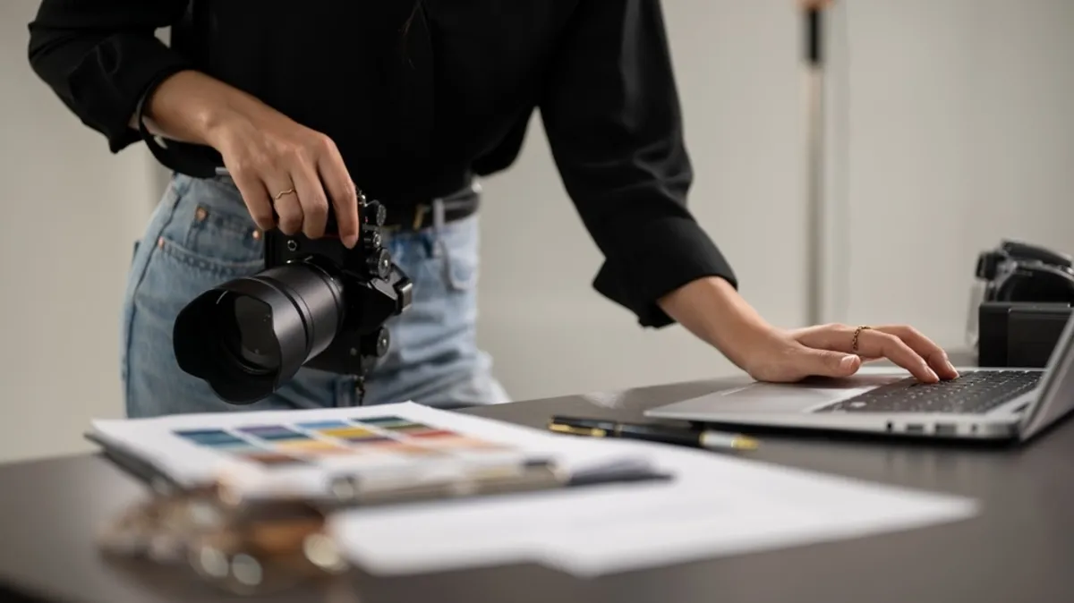 A photographer at a laptop with a camera in his hands | Skylum Blog