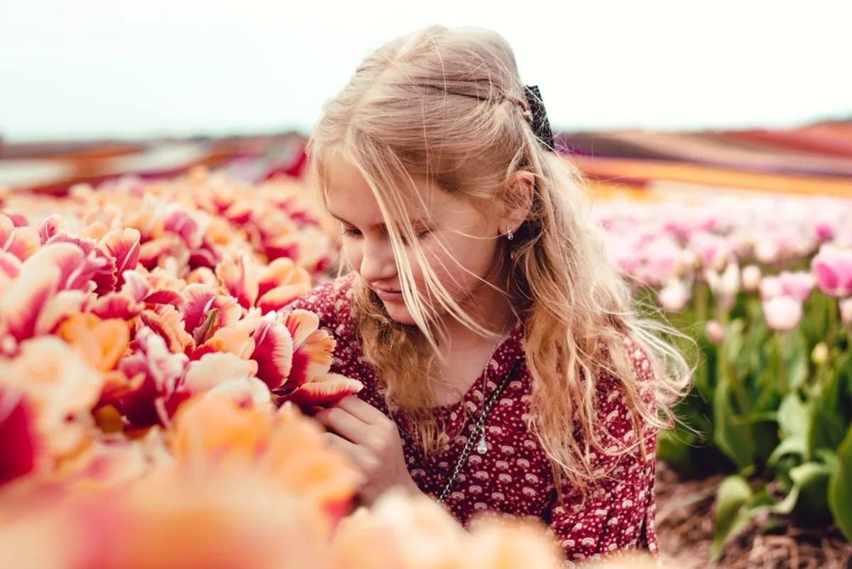 A girl smelling tulips in a tulip field | Skylum Blog