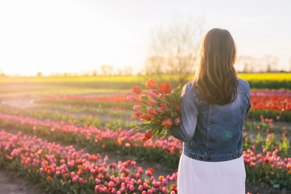 A girl with a bouquet of tulips in a tulip field | Skylum Blog