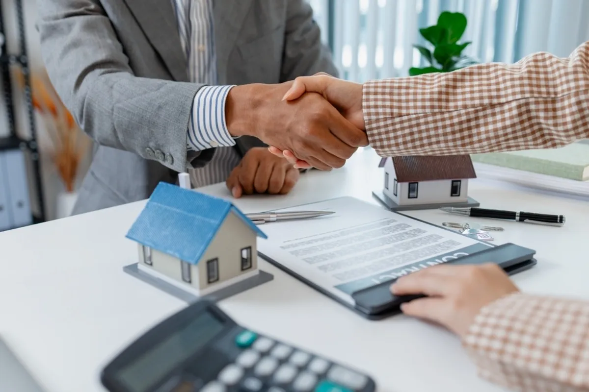 People shake hands in a real estate office