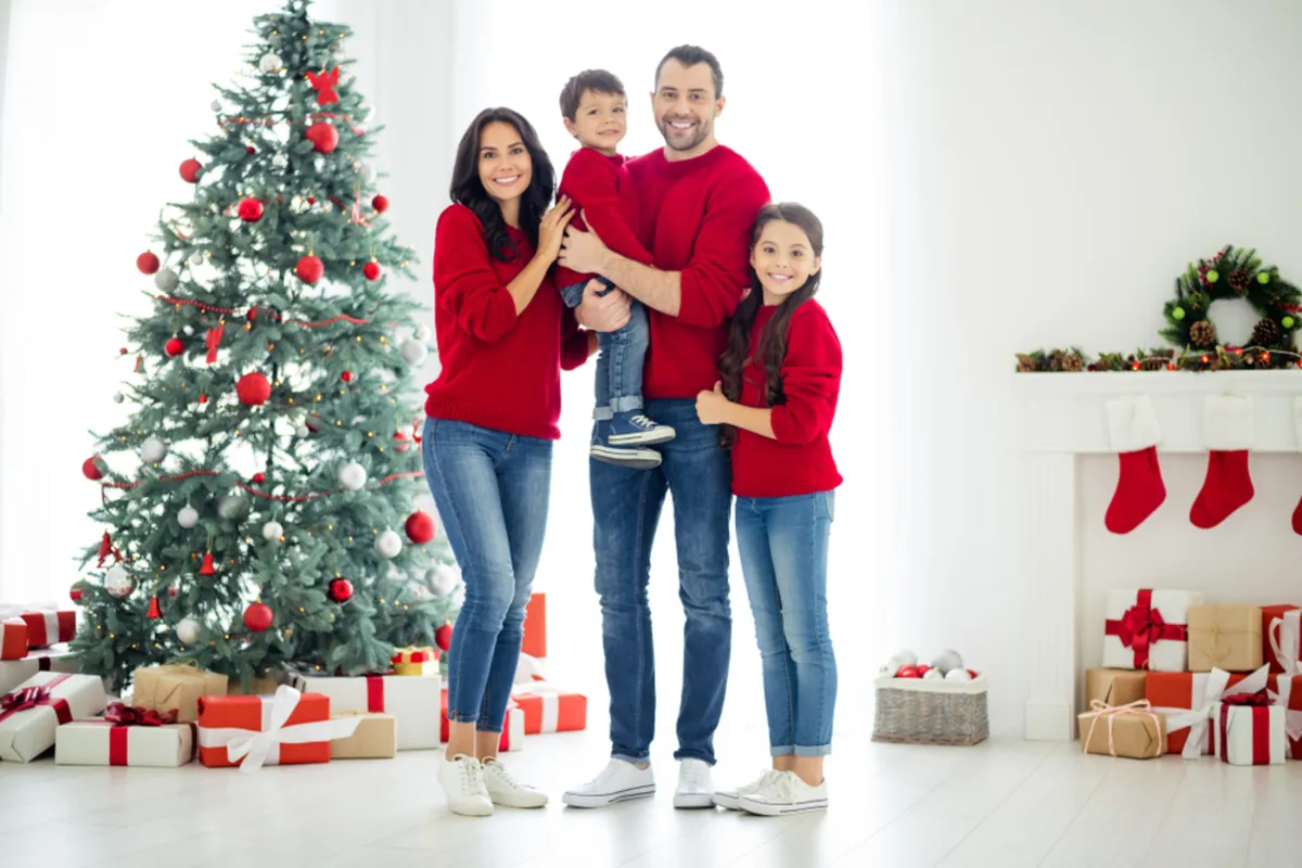 A family in identical clothes near a Christmas tree | Skylum Blog