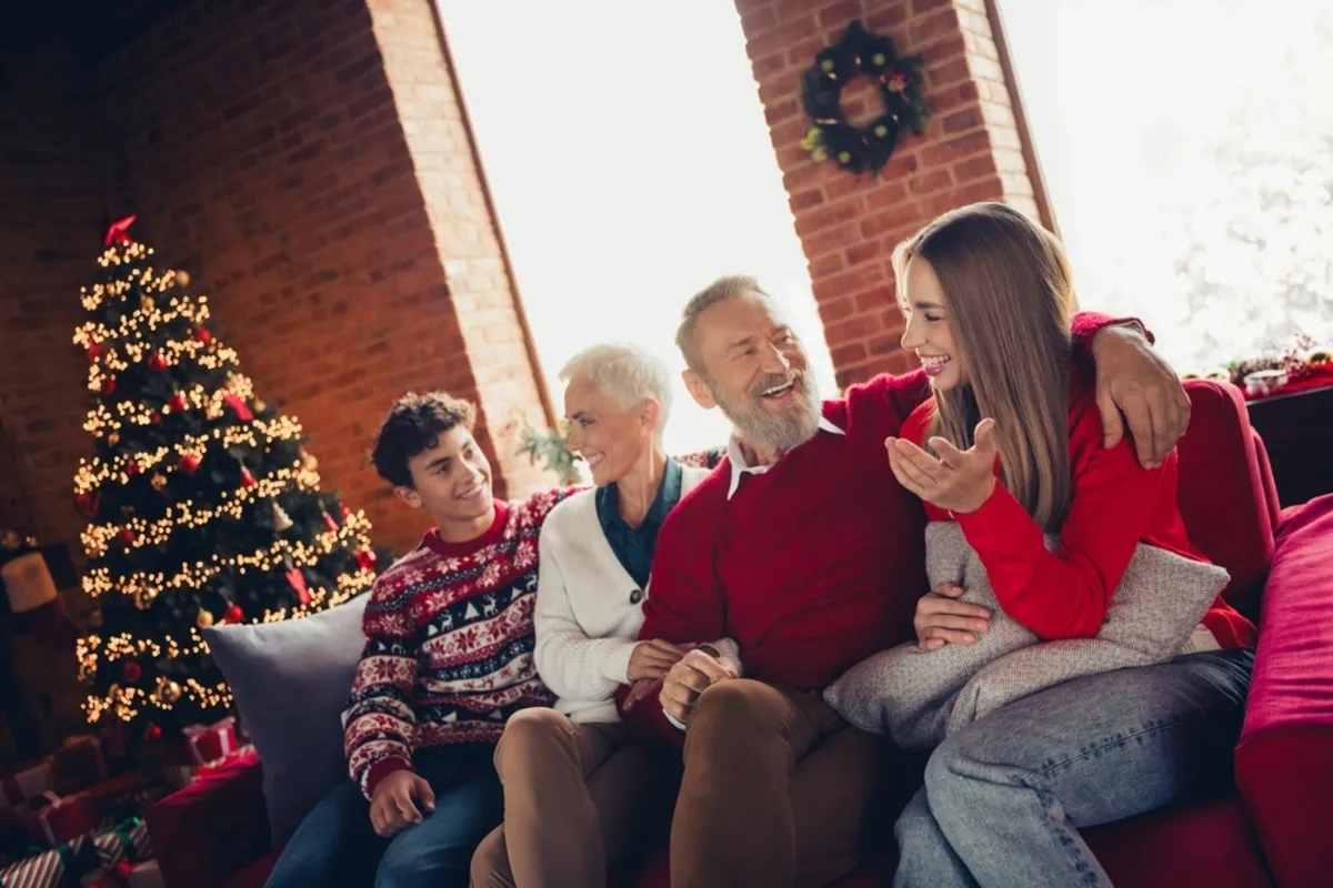 A family is sitting on a sofa by the window and talking | Skylum Blog