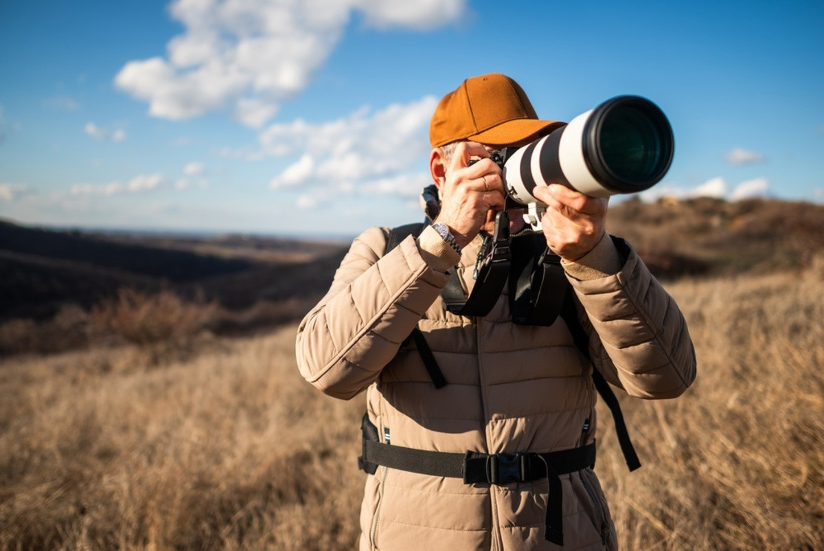 A photographer with a camera in nature | Skylum Blog