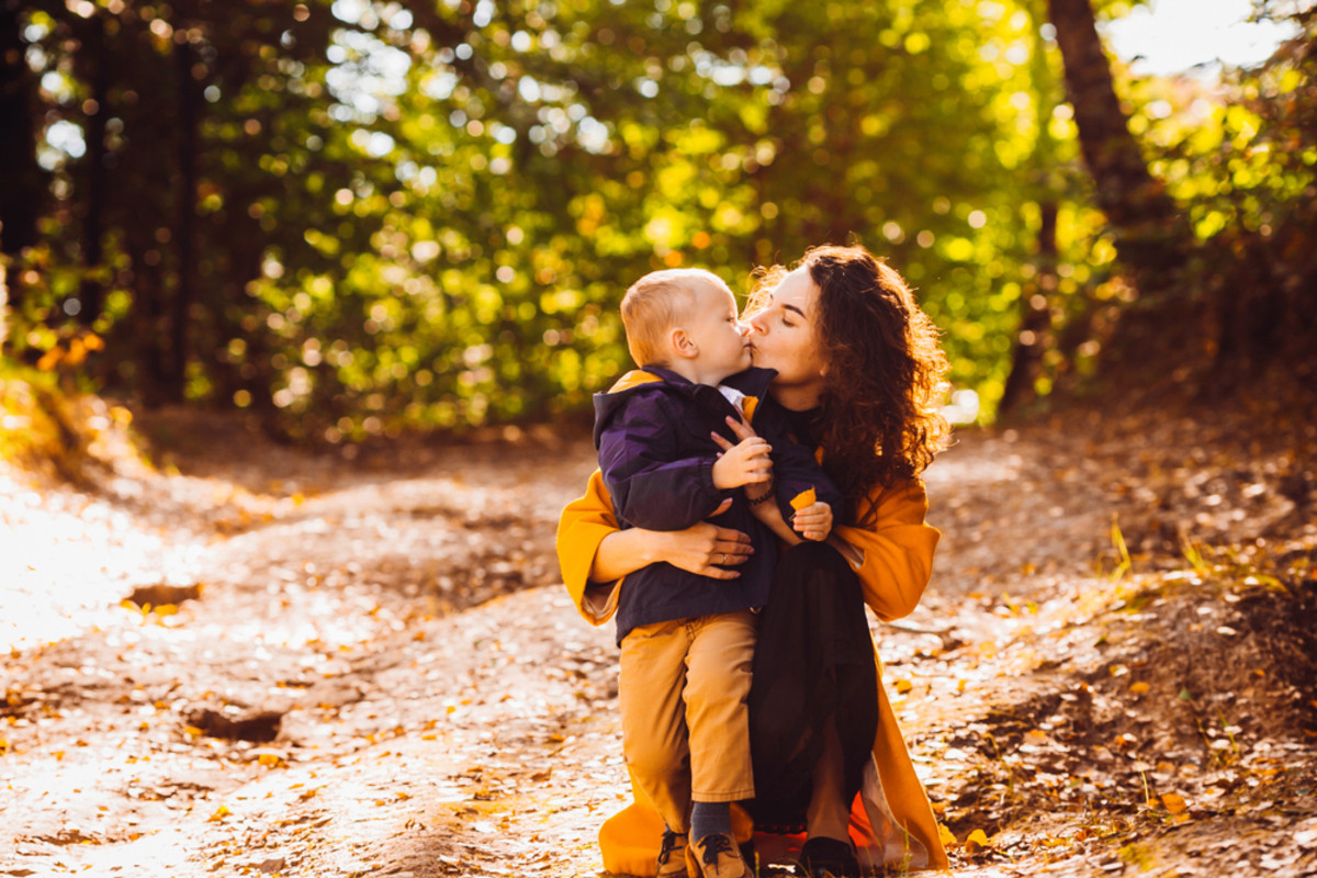 Mutter hält ihren Sohn in einem Herbstwald | Skylum Blog

