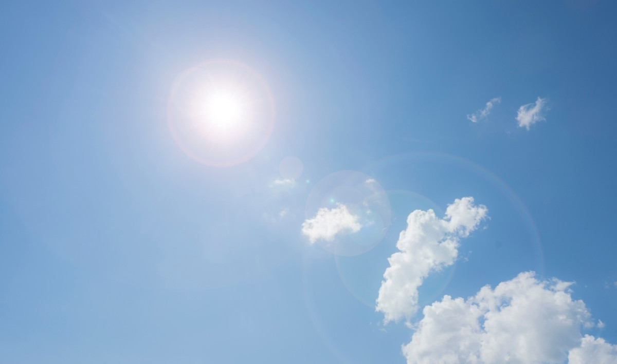 Bright sun flare in a clear blue sky with clouds | Skylum Blog

