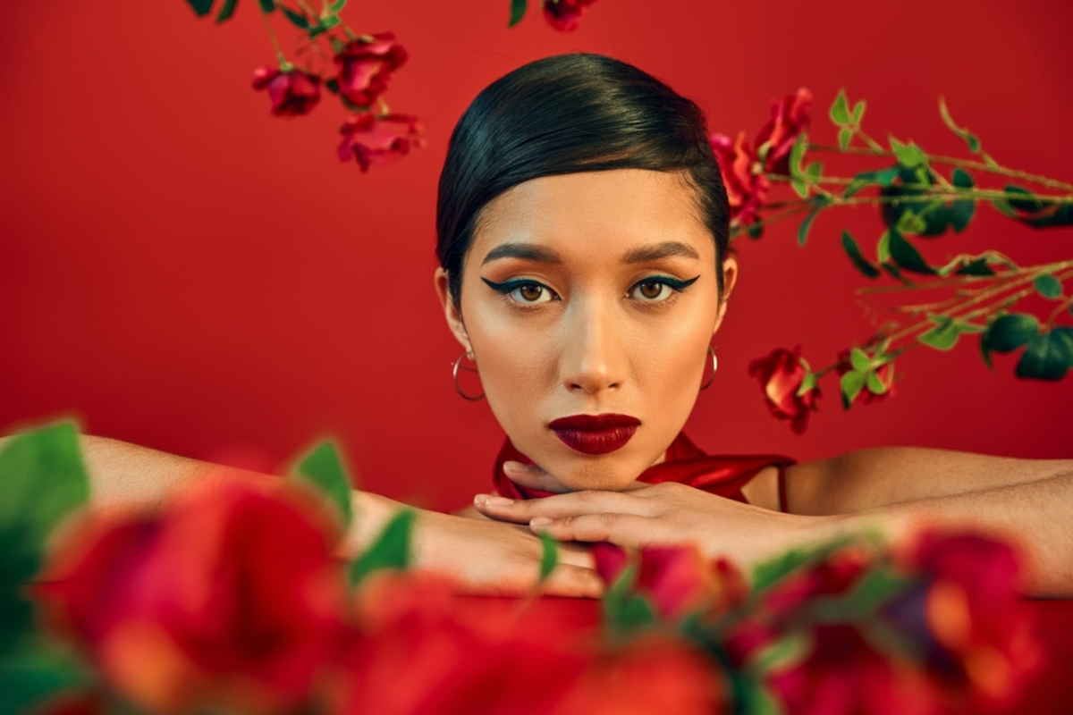 Portrait of a girl on a red background with flowers on the sides | Skylum Blog

