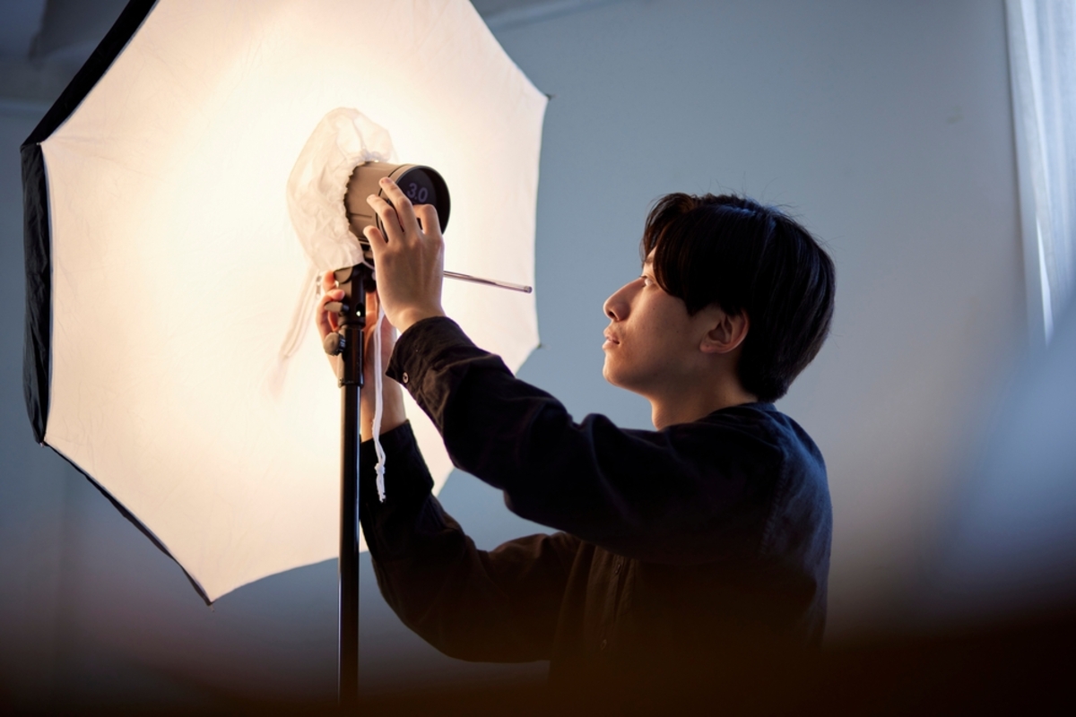 A photographer sets up studio lighting | Skylum Blog

