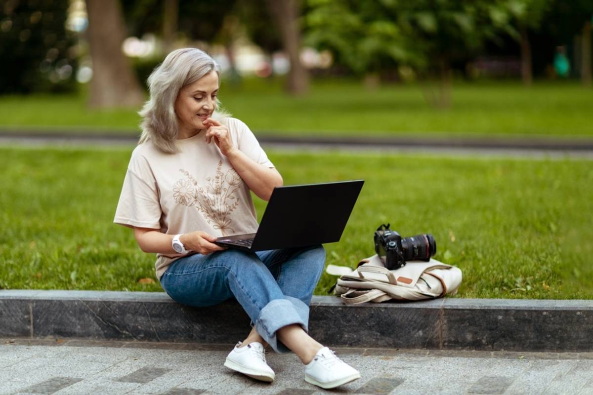 A photographer with a laptop edits photos on the street | Skylum Blog