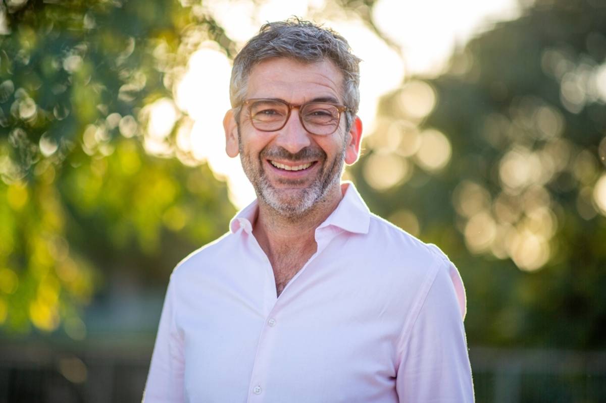 Smiling man in a light shirt with sunlit park background | Skylum Blog

