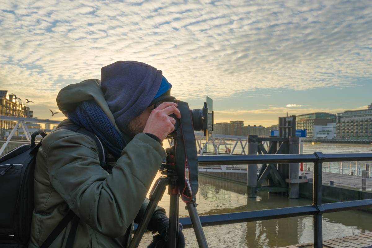 A photographer takes a photo using an ND filter | Skylum Blog

