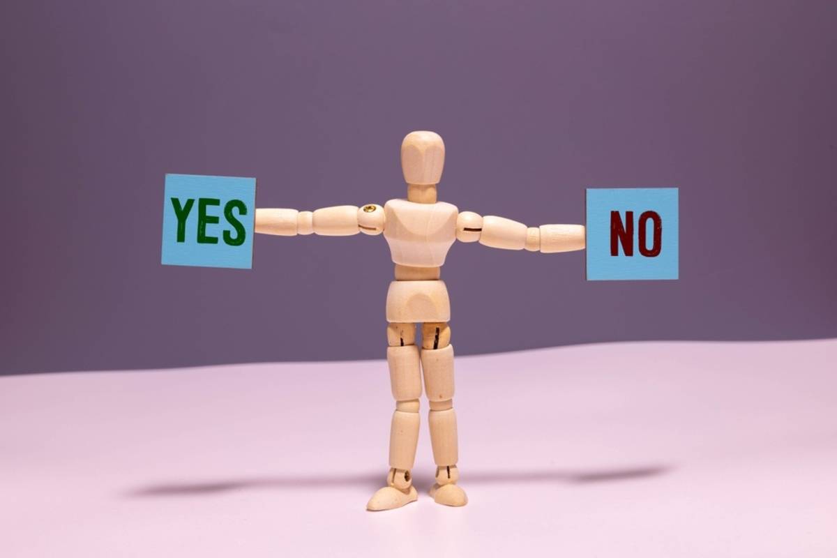 A wooden man holds a yes and no sign in his hands | Skylum Blog

