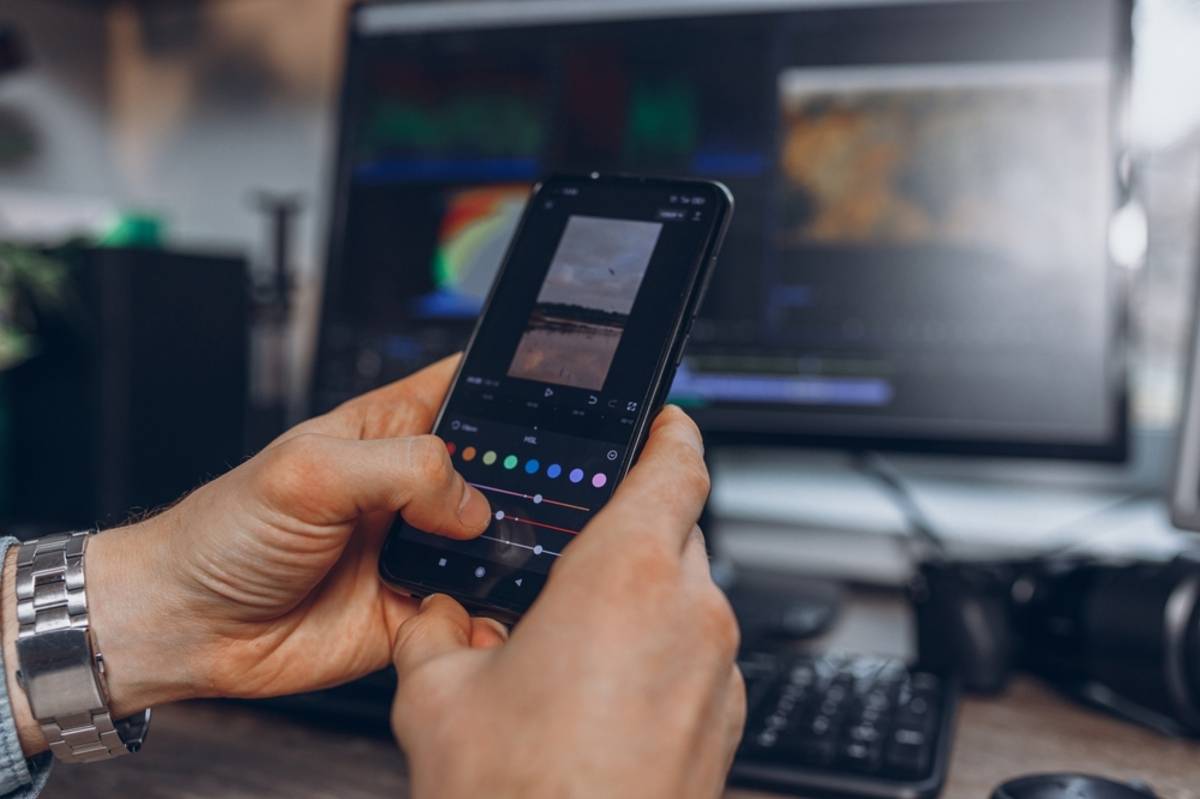 A photographer edits a photo on a smartphone | Skylum Blog

