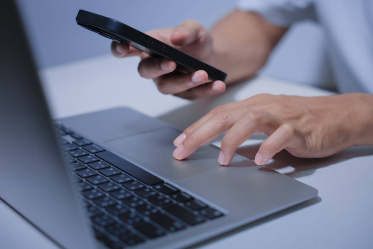 A guy works on a laptop and a phone | Skylum Blog

