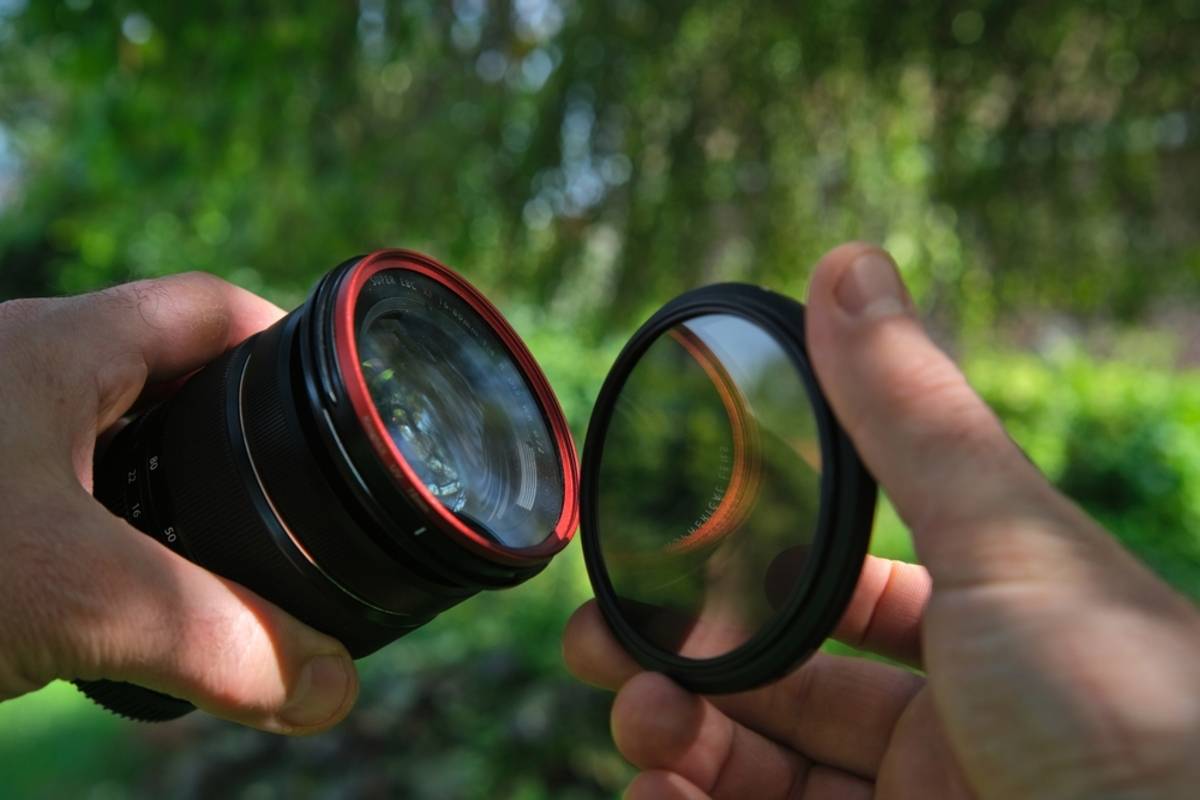 A photographer puts an ND filter on his camera | Skylum Blog

