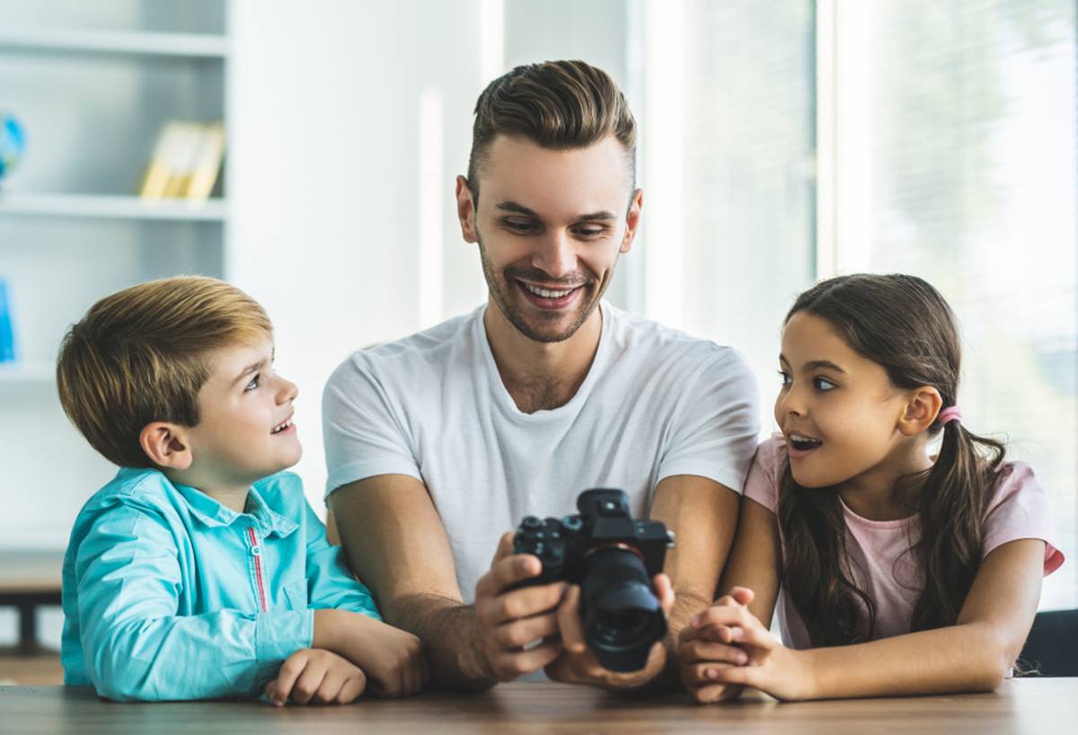 A photographer shows a camera to children | Skylum How-to

