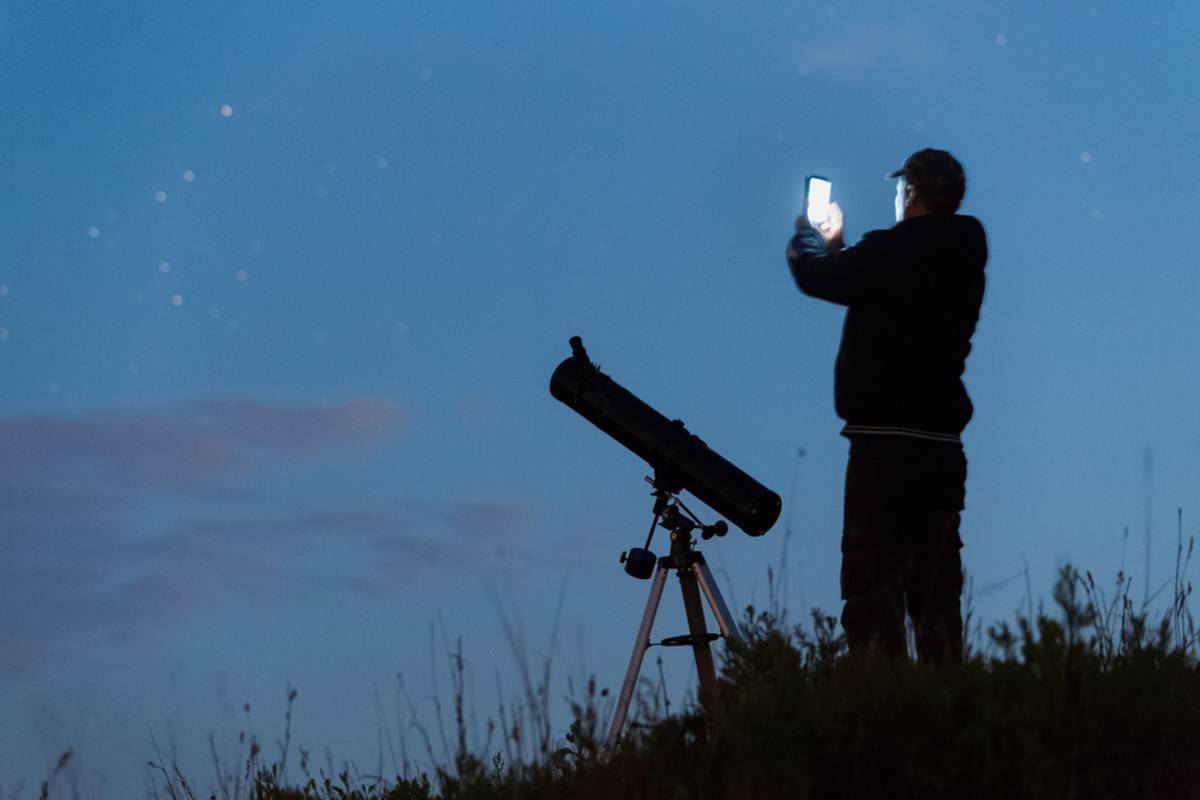 A man takes a photo of a star on a smartphone | Skylum How-to