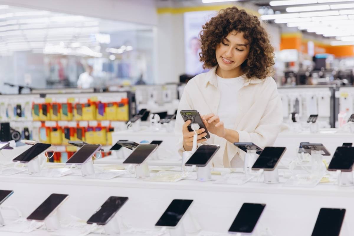 A girl chooses a smartphone in a store | Skylum Blog


