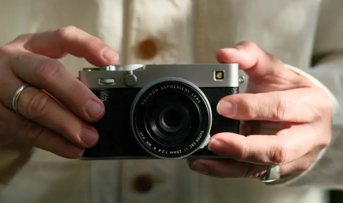 A man holds a Fujifilm X-E5 camera | Skylum Blog