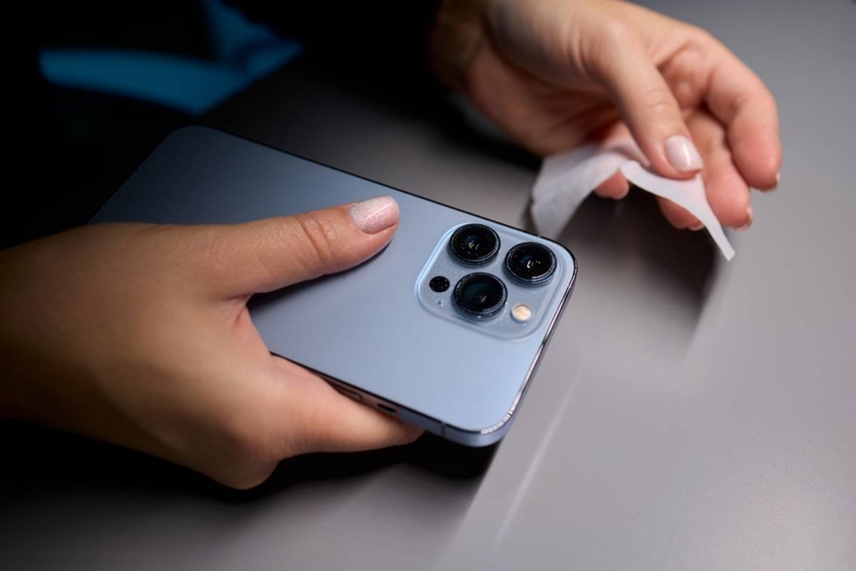 A girl wipes her smartphone camera | Skylum How-to