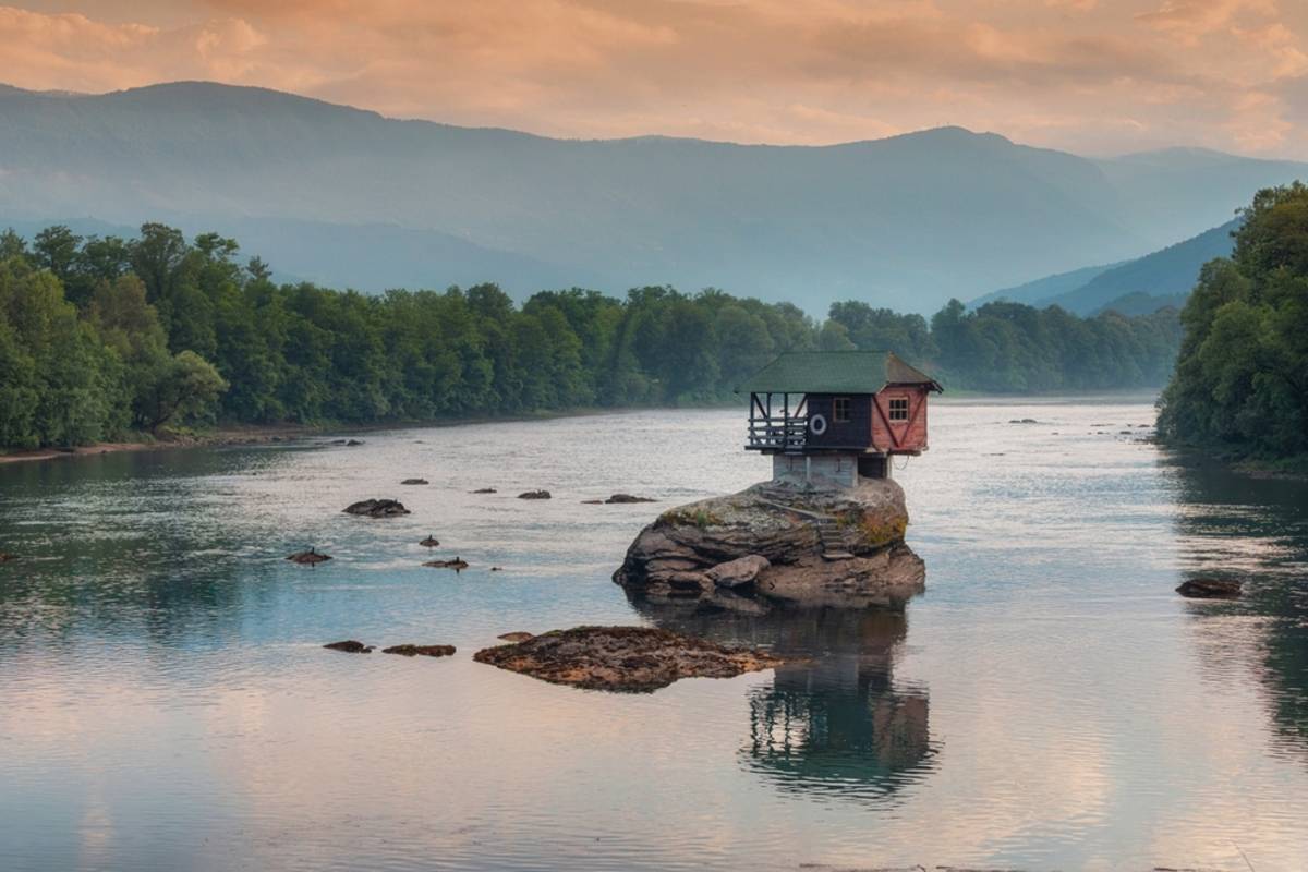A house standing on a rock in the water | Skylum Blog
