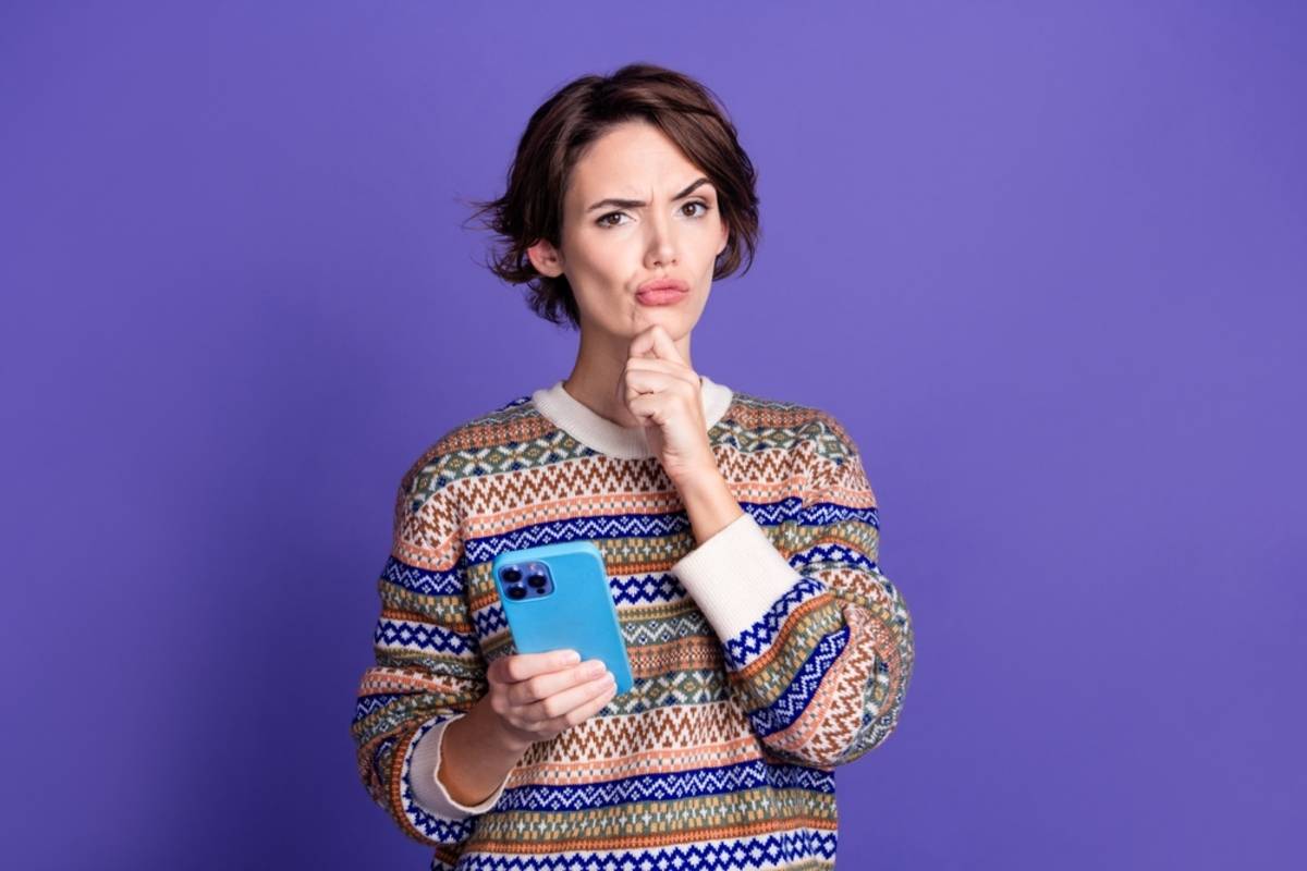 A girl thinks with a smartphone in her hands | Skylum Blog

