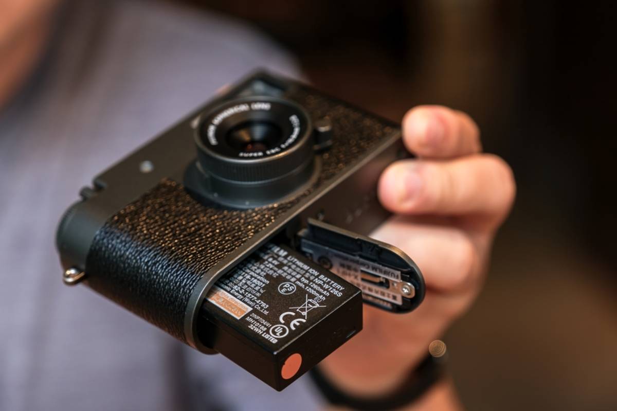 Le Fujifilm X Half en main pour vous montrer le compartiment à batterie | Blog Skylum

