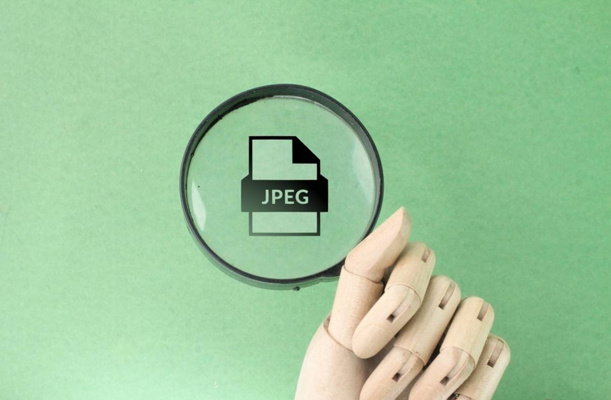 JPEG-Symbol, gehalten von einer Holzhand | Skylum-Blog

