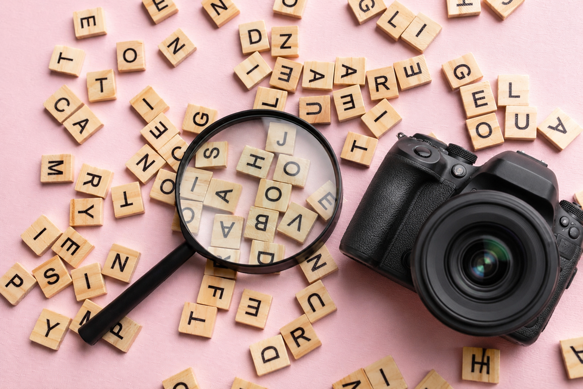 Kamera und Lupe auf verstreuten Buchstabenplättchen | Skylum-Blog

