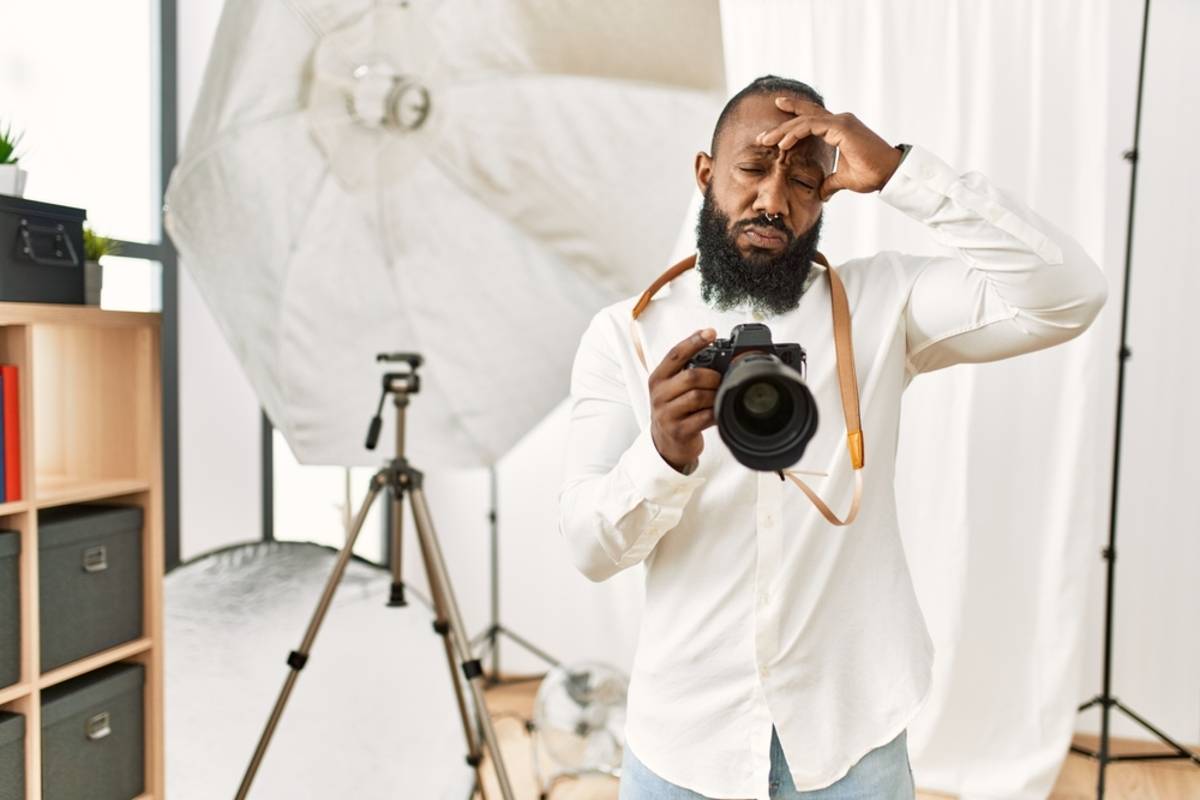 Un fotógrafo ajustando la cámara en un estudio muy luminoso | Blog de Skylum