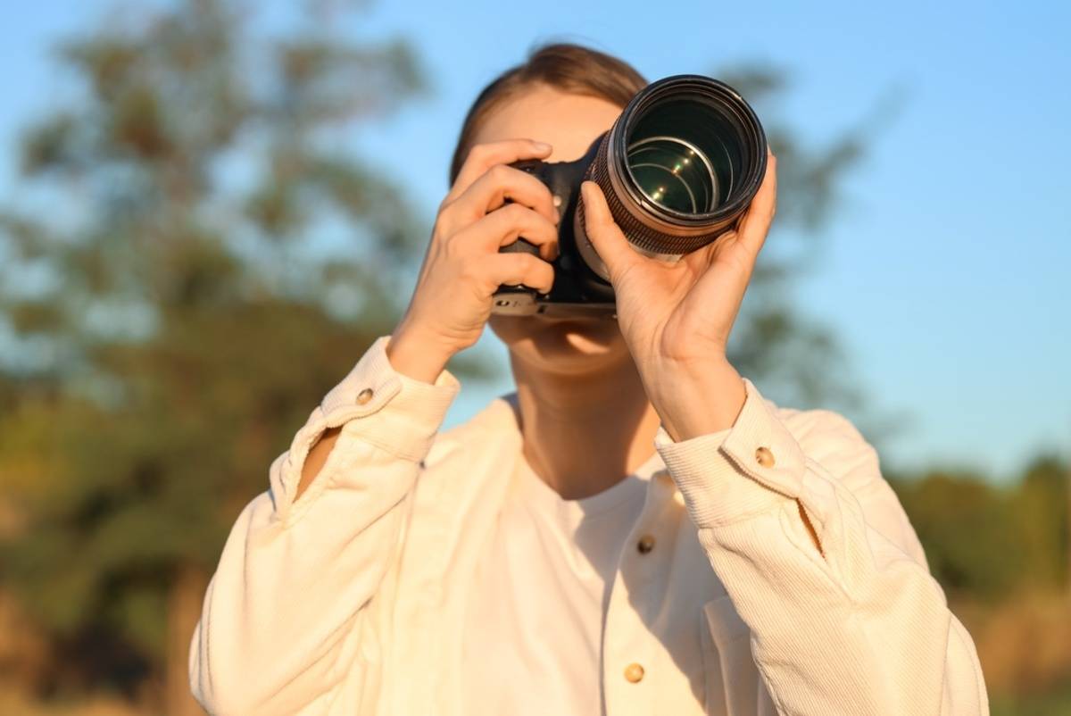 Photographer taking a photo outdoors | Skylum Blog

