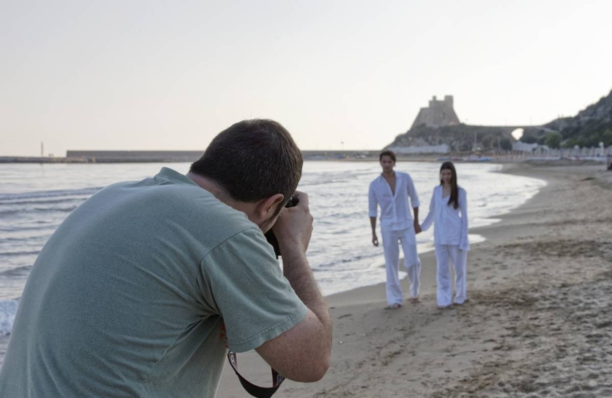 A photographer takes pictures of newlyweds on the beach | Skylum Blog

