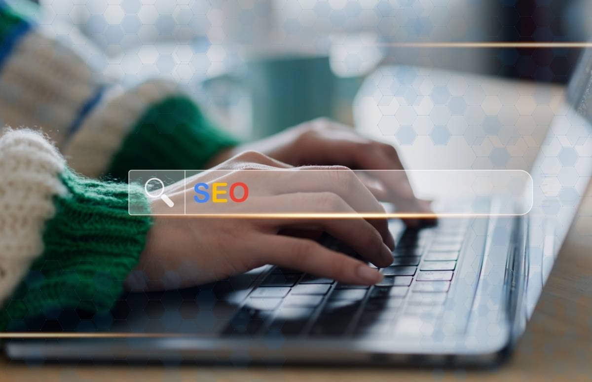 Hände, die auf einem Laptop tippen, daneben liegt ein Notizbuch | Skylum-Blog

