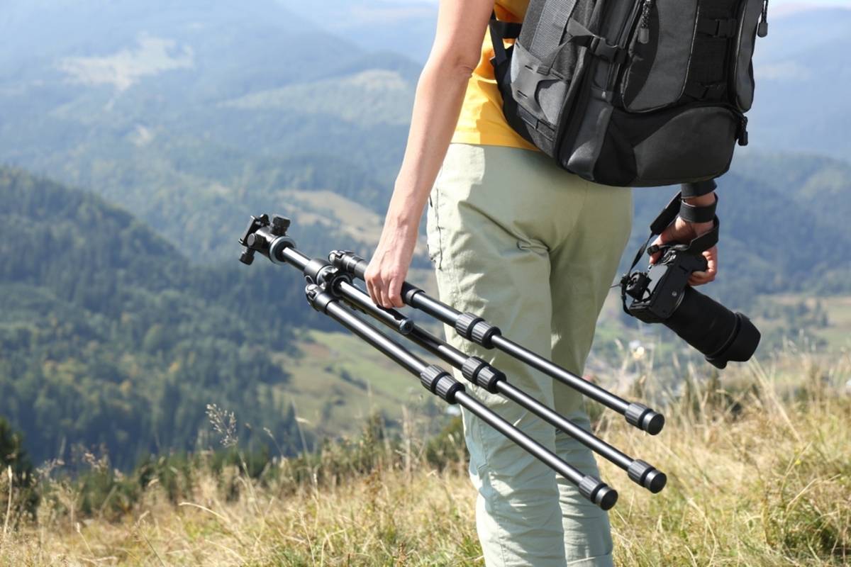 A photographer with a tripod in his hands | Skylum Blog


