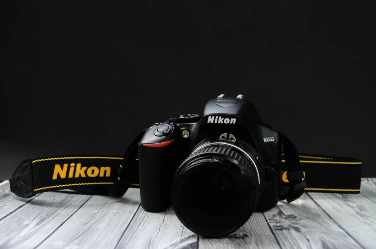 Nikon D3500 camera with strap on dark background | Skylum Blog

