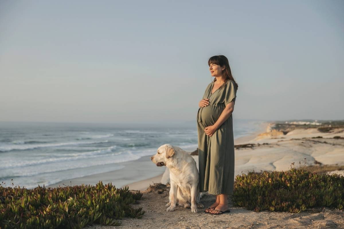 Pregnant woman standing on a beach at sunset | Skylum Blog

