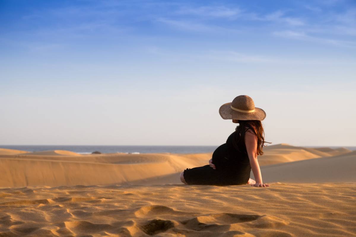 Pregnant woman standing among beach dunes | Skylum Blog

