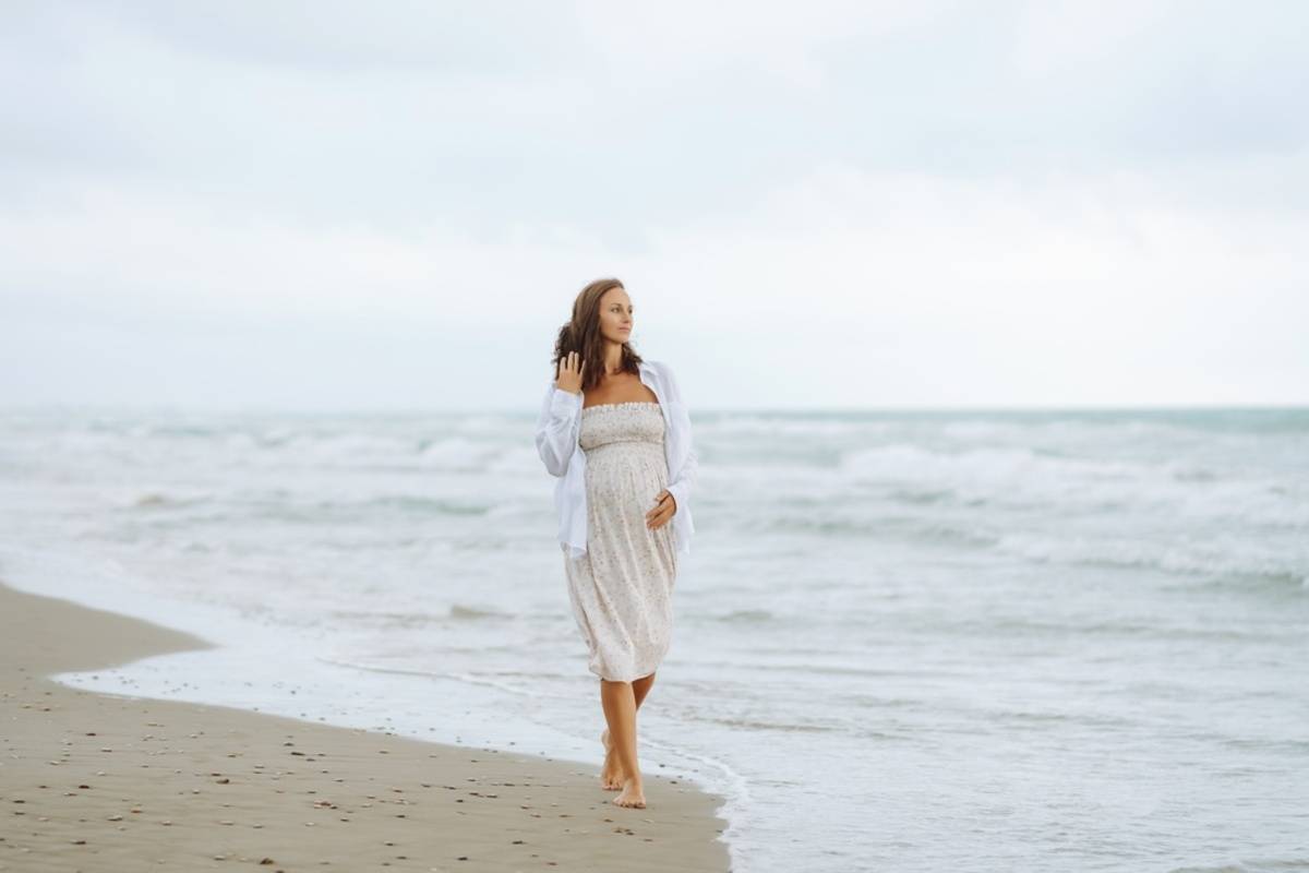 Pregnant woman walking alone along the beach | Skylum Blog

