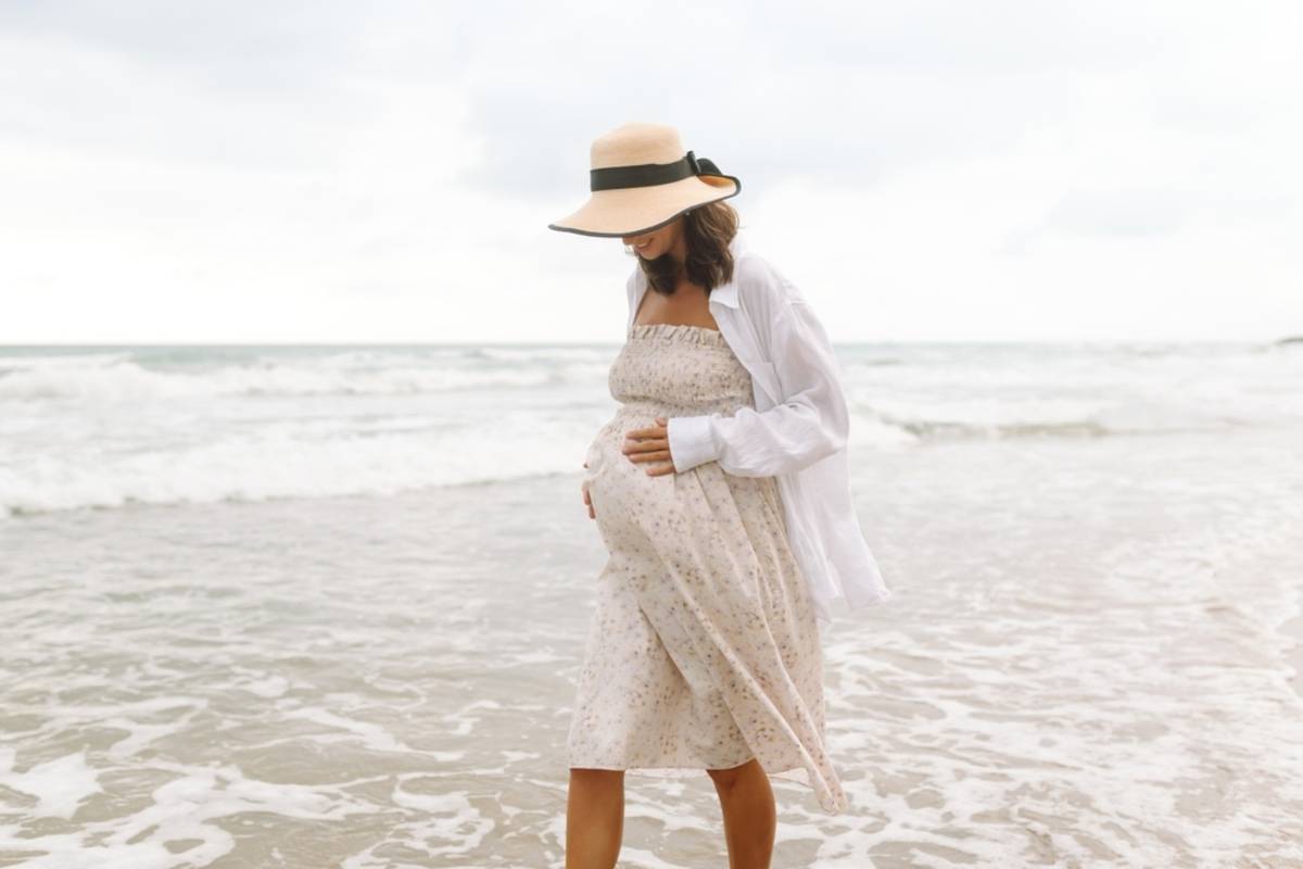 Woman in a white dress walking on a sandy beach | Skylum Blog

